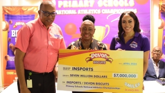 Devon Biscuit&#039;s brand manager, Sherene Bryan (right), presents a symbolic cheque to Minister of Sports, Olivia Grange (centre), and George Ledgister, acting Executive Director of INSPORTS at the event&#039;s launch.
