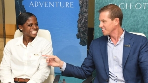 Olympic medalist and three-time National Champion, Megan Tapper (left) and Executive Chairman of Sandals Resorts International share a laugh after inking the deal.