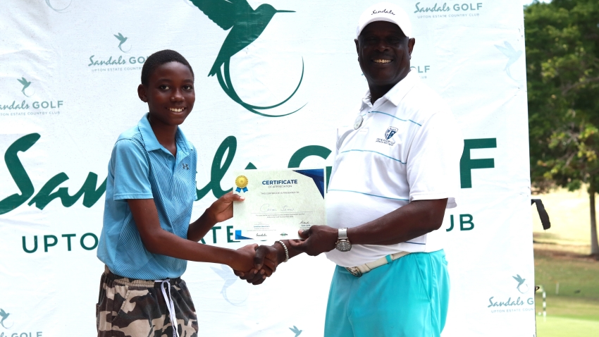 Top performer Cavani James (left) accepts his winning certificate from Sandals golf pro and junior coach, Bill Williams.
