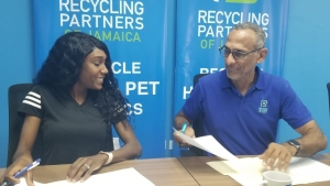 Olympian Natoya Goule smiles with Dr Damien King, Chairman of Recycling Partners of Jamaica during a signing of an agreement on Wednesday under which Goule will become an ambassador for the company.