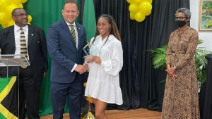 Briana Williams receiving her Heritage Award from Consul General Oliver Mair