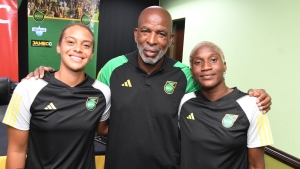 Reggae Girlz goalkeeper Rebecca Spencer (left) shares a photo opportunity with Head coach Lorne Donaldson and teammate Deneisha Blackwood