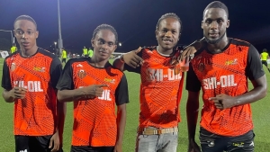 Dancehall entertainer Jahshii (second right) posing with Slingerz FC players after their 4-1 victory over Fruta Conquerors on Tuesday night.