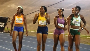 An emotional Krystal Sloley (second left) reacts after her 11.09s clocking.