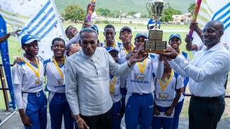 Manchester celebrates winning the 32nd Kingston Wharves U15 Cricket Competition at Up Park Camp. Sharing in the celebration with the team were Billy Heaven (L) president of the Jamaica Cricket Association and Mark Williams (R) CEO of Kingston Wharves. Manchester defeated St. Mary by eight wickets to capture the title from the defending champion.