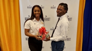 Shelly-Ann Fraser-Pryce presenting a gift basket to Brenton Bartley, who was among the first cohort of scholarship recipients of the Pocket Rocket Foundation in 2013. Bartley, who is now a Civil Engineer, was the guest speaker at the recent ceremony at the Jamaica Pegasus where seven more student-athletes received scholarships from the foundation.