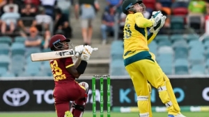 Alick Athanaze plays a shot as Australia&#039;s wicketkeeper Josh Inglis looks on.